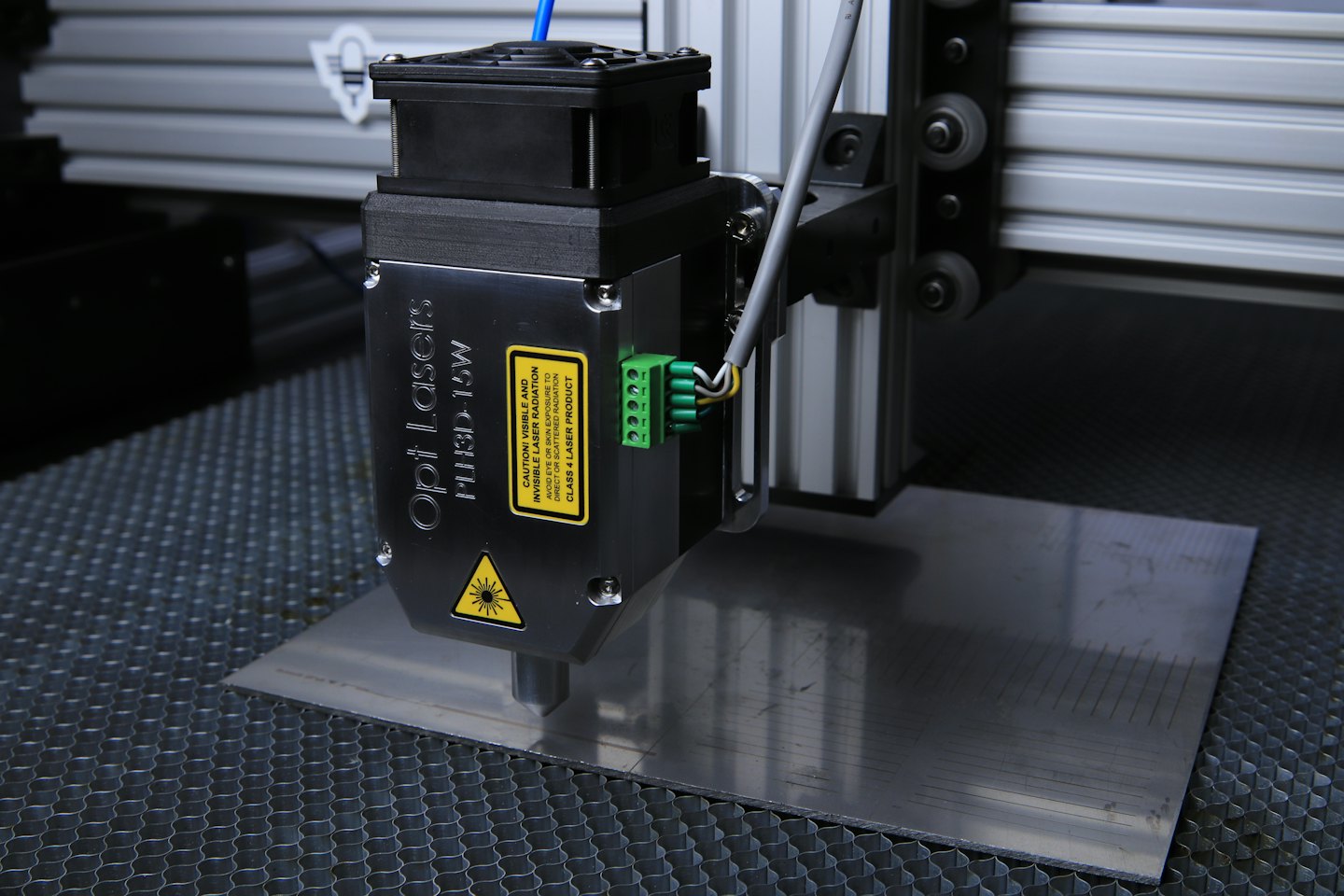 Lasergravurmaschine graviert Linien auf gebürsteter Metalloberfläche.